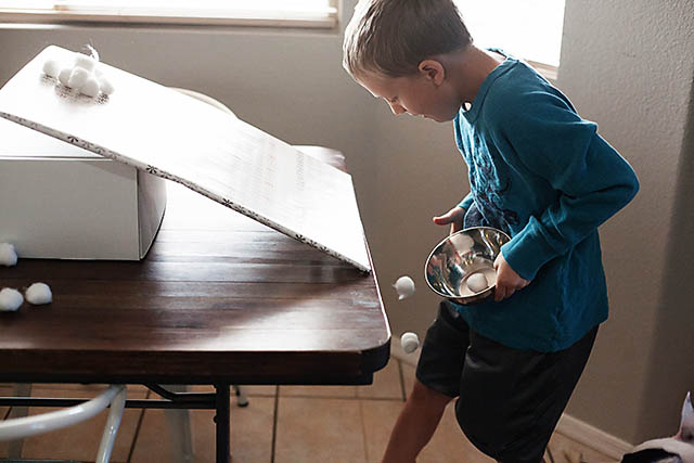 Snowball roll game using cotton balls from All for the Boys blog