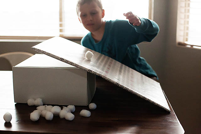Snowball roll game using cotton balls from All for the Boys blog