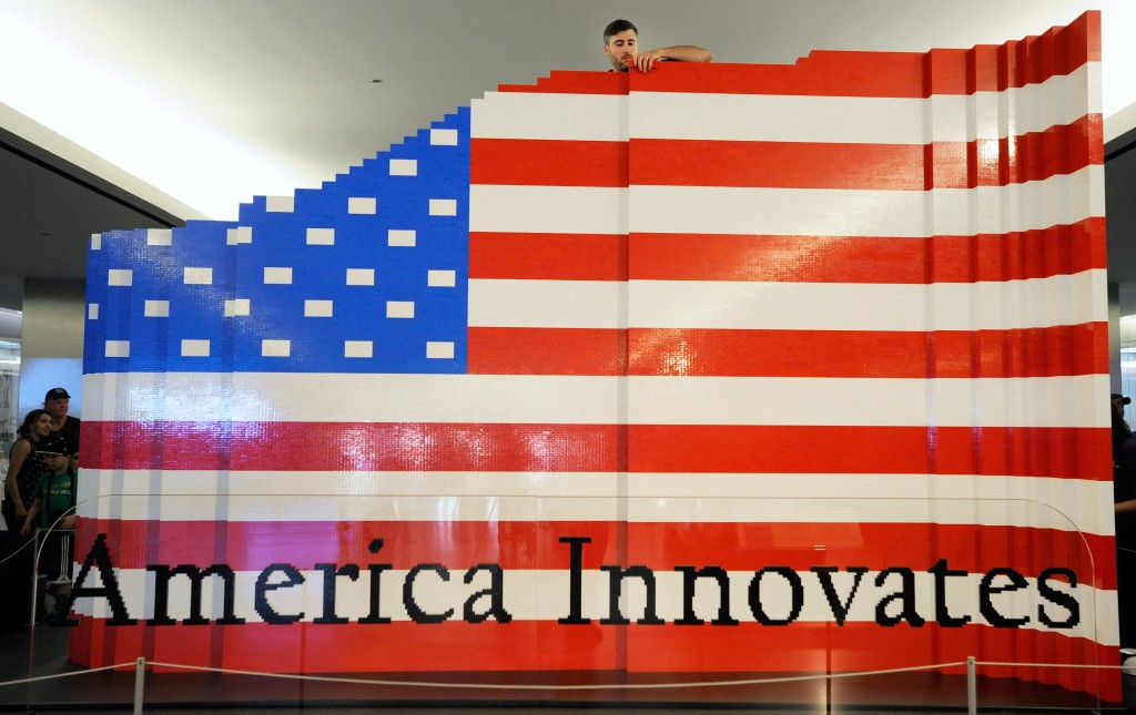 LEGO master builder Chris Steininger places a brick while building the world's largest LEGO American flag to celebrate the opening of the Innovation Wing at the National Museum of American History on Wednesday, July 1, 2015 in Washington. More than 15,000 museum visitors helped LEGO master builders create the 9.5-by-14-foot flag using more than 100,000 LEGO bricks. (Steve Ruark/AP Images for LEGO)
